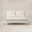 Front view of Nolven Softline Upholstered Bed in warm ivory fabric with a soft padded headboard and slim metal legs.