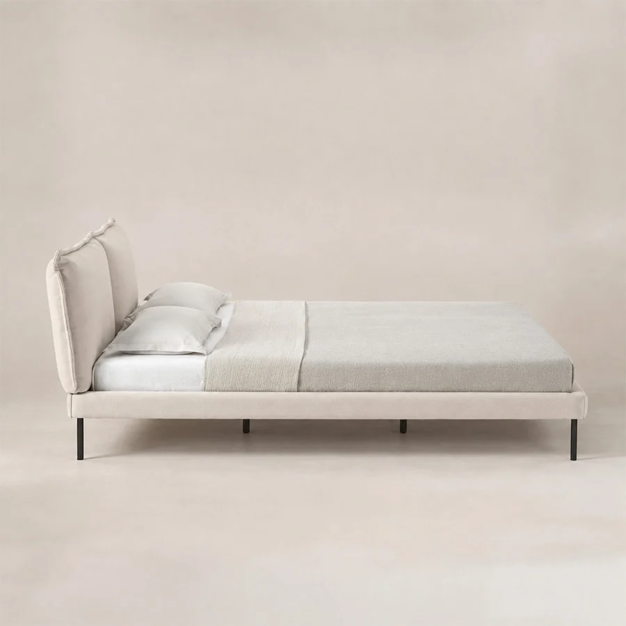 Nolven Softline upholstered Off-White bed side view Side view of Nolven Softline Upholstered Bed in warm ivory fabric with padded headboard and slim metal legs.