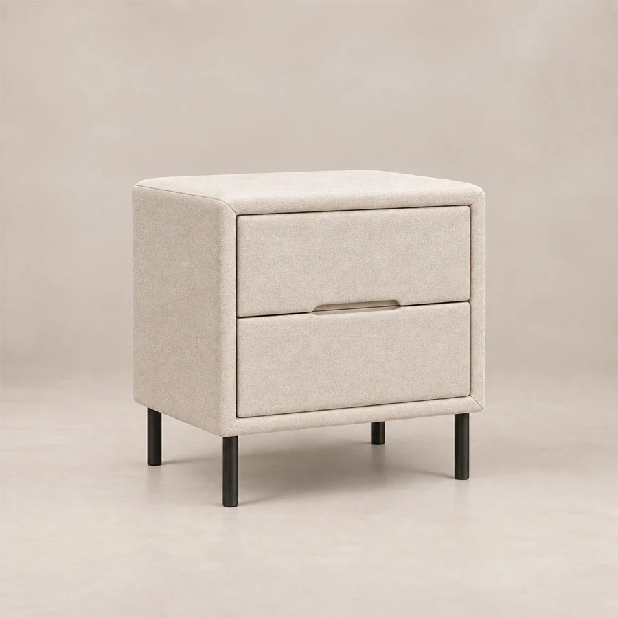 Nolven Softline upholstered Off-White side table Angled view of Nolven Softline matching two-drawer bedside table in warm ivory upholstery with slim black metal legs.