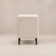 Side view of Nolven Softline matching bedside table in warm ivory upholstery with slim black metal legs.