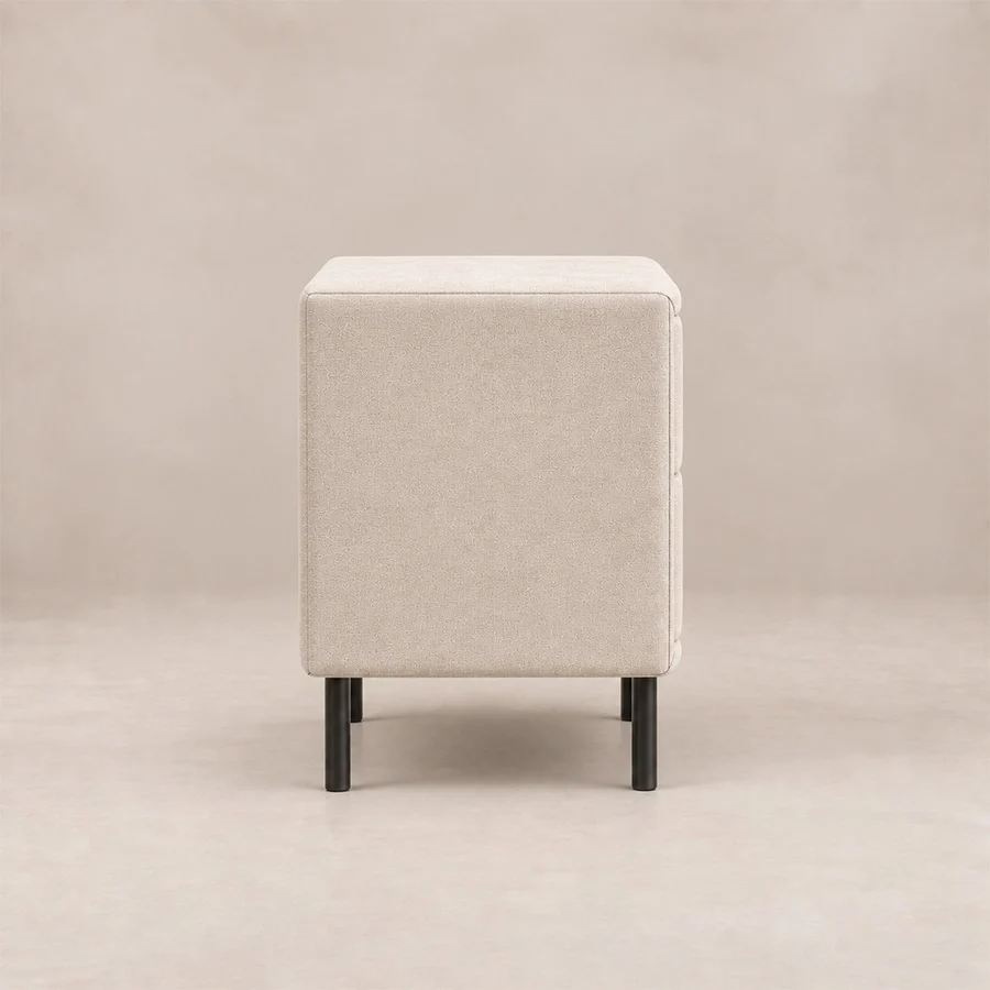 Nolven Softline upholstered Off-White side view Side view of Nolven Softline matching bedside table in warm ivory upholstery with slim black metal legs.