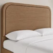 Close-up of Soreven Archline Bed in Warm Walnut finish showing the rounded arched headboard and wood grain detail.