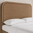 Close-up of Soreven Archline Bed in Warm Walnut finish showing the rounded arched headboard and wood grain detail.