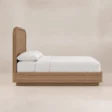 Side view of Soreven Archline Bed in Warm Walnut finish with arched headboard and low wooden frame.