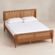 Angled top view of Maroven Platform Grid Bed with warm wood frame, woven cane headboard, footboard, and tapered legs.