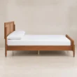 Side view of Maroven Platform Grid Bed in warm wood finish with woven cane headboard, raised wooden frame, and tapered legs.